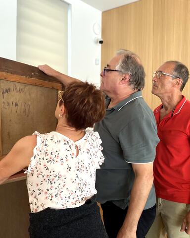 Les enfants de Charles Féola examinant le dos d'une toile de leur père